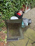 Assorted Garden Items garden bench, small side table, tall bird table, various plastic containers, bag of garden waste, 3 doormats PR5 - removed for £125