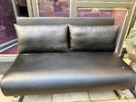 2-seater sofa bed Black faux leather 2 seater sofa bed in used condition with 1 small scratch and a few wear and tear places. Fully functional and light. Easy to use. Brand: Dwell. Fire safety label still attached TW8 - removed for £50