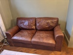 Sofa 2 seater Brown leather 2 seater sofa
174cm length
90cm depth
90cm height
Well used but still in very comfortable condition. Broken zip on one of seat cushions as shown by photograph. W4 - removed for £65