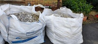 Two bags of used white pebbles collected by Kevin Alderton
