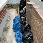 Rubble and timber 8 bags rubble (stone, concrete, plaster, etc), 2 bags lightweight timber (old fence), fragments of concrete fence post, 2 metal post holders, approx 6 lengths of timber (various lengths). E15 - removed for £90