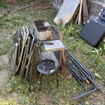 Household waste, scrap metal One broken down sofa bed frame - each piece liftable by one person. Two iron gates. A few MDF cabinet pieces. Barbecue, several metal poles, folding chairs. Broken lawnmower and three bags of DIY waste. Small pile of broken down timber pallets. Corrugated plastic sheeting which could be reused. Four plastic garden chairs and plastic garden table (not pictured but very lightweight). E17 - removed for £175