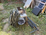 Household waste, scrap metal One broken down sofa bed frame - each piece liftable by one person. Two iron gates. A few MDF cabinet pieces. Barbecue, several metal poles, folding chairs. Broken lawnmower and three bags of DIY waste. Small pile of broken down timber pallets. Corrugated plastic sheeting which could be reused. Four plastic garden chairs and plastic garden table (not pictured but very lightweight). E17 - removed for £175