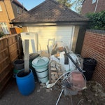 Garden and house rubbish All items from the brown fence to the brick wall. Includes plastic bins, water butts, plastic pots, rolls of old vinyl flooring small pallet of plasterboard and other building waste, fridge freezer. SL3 - removed for £155