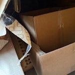 interior door, card/storage A damaged (possibly could be used) interior door. Packing material, broken plastic boxes and wooden box table. SN7 - removed for £130