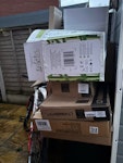 boxes, bike, chair+cushion… A junior bike, a dismantled chair with cushion, wood flooring pieces, shelving pieces, 2 side table tops, bag of packing paper and several large boxes. ST16 - removed for £104