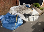 Mixed Waste from Garden 1 x Wood planter, 1 x small skip bag with a some sharp sand left in it, 1 x large skip bag with sand, rock and pebbles from digging up the front garden (not filled to the brim, but there is a lot in there). In driveway infront of Garage. RH12 - removed for £429