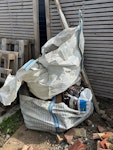 mixed waste one tonne bag contains broken insulation boards (very light) and the other contains mixed waste. 
Also includes broken terracotta pot, a chimney cap, a dismantled wooden swing set, wooden pallets and a bin containing some glass, a parasol, and mixed pvc and timber. DA4 - removed for £104