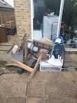 rubbish bags, wood and junk its a lot of random junk, 2 old tables,some rotten wood and bags with rubbish, some containers full of metal and plastic parts W4 - removed for £214