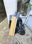 1 small pile of rubbish Vinyl outdoor flooring. Random bits of rubbish. A tyre. A baby bath. A broken fan. Etc. IG11 - removed for £71