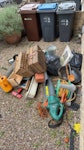 Garden Junk and tools One wooden shelf, one old lawn blower 2 old baskets, plant plots in bags, old storage container, a number of old garden tools. SW19 - removed for £83