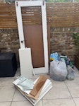 Door, shelves, garden waste Broken door edge frame, thing ply sheet, old shelves/brackets (good condition), bag of glass from door, some bags of garden waste N7 - removed for £88