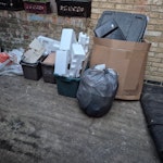 Building waste, astroturf etc Astroturf roll, cardboard and packaging, building waste (tiles in plastic buckets, three heavier building material bags) N19 - removed for £143