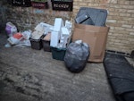 Building waste, astroturf etc Astroturf roll, cardboard and packaging, building waste (tiles in plastic buckets, three heavier building material bags) N19 - removed for £143