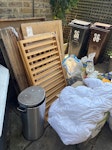 Pallet, bag rubble, soil, junk Pallet, old wooden cot, box of papers, old hosereel, duvet, 4 bags of rubble, 2 bags of soil, freestanding metal and small household items E8 - removed for £130