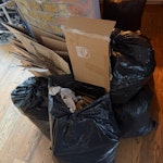 Cardboard and rubbish bags flattened cardboard packaging and 8 tied black bags of general household waste. The waste is currently stored indoors on the ground floor with easy access to parking. TW2 - removed for £83