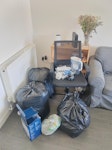 black bags and chair black bag contains duvet and pillows. morrisons bag contains plates and bowls. blue box contains dehumidifier. office chair needs to be thrown out, as well as the britta filter, extension cord, laptop stand, camera and scent diffuser that is on top of the chair. BN2 - removed for £77