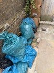 Garden waste and tiles Garden soil and some greenery in blue bags. Old concrete tiles as shown. Some carboard packaging and miscellanous rubbish SW11 - removed for £235