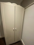 White IKEA two-door wardrobe IKEA HENSVIK wardrobe, 80W x 50D x 180H cm. Functional/assembled, stored on side; one shelf removed but included. Scuffs/marks in several areas, plus chips/damage to the bottom corner and top edge. Fibreboard back attached but not flush where nails are missing. Move assembled or dismantle. Collect by 5pm Tue 8 Sept. Lift/trolleys available. TW8 - removed for £52