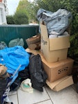 cardboard and rubbish bags cardboard, rubbish bags, a bag with wooden planks and a old dog bed and a suitcase W12 - removed for £99