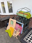 Garden toys/storage equipment An old plastic garden storage box (deconstructed), children’s plastic garden playhouse (deconstructed), a metal plant pot rack, small table football table and tarpaulin/furniture cover. E4 - removed for £83