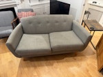2 seater sofa It's a compact two-seater sofa in a mid-century or retro style. It's upholstered in a mid-grey woven fabric with a heathered, slightly flecked texture, a bit like linen. W8 - removed for £71