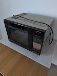Combination microwave Freestanding combination microwave oven, weighs 31Kg. On a table just inside front door EN7 - removed for £192