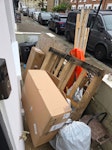 Shed, cardboard & bags Old shed dissasembled into panels, a pallet, some rubbish bags, old plant pot, light/thin piece of metal, two cardboard boxes. All placed in front garden for easy access. SW12 - removed for £83